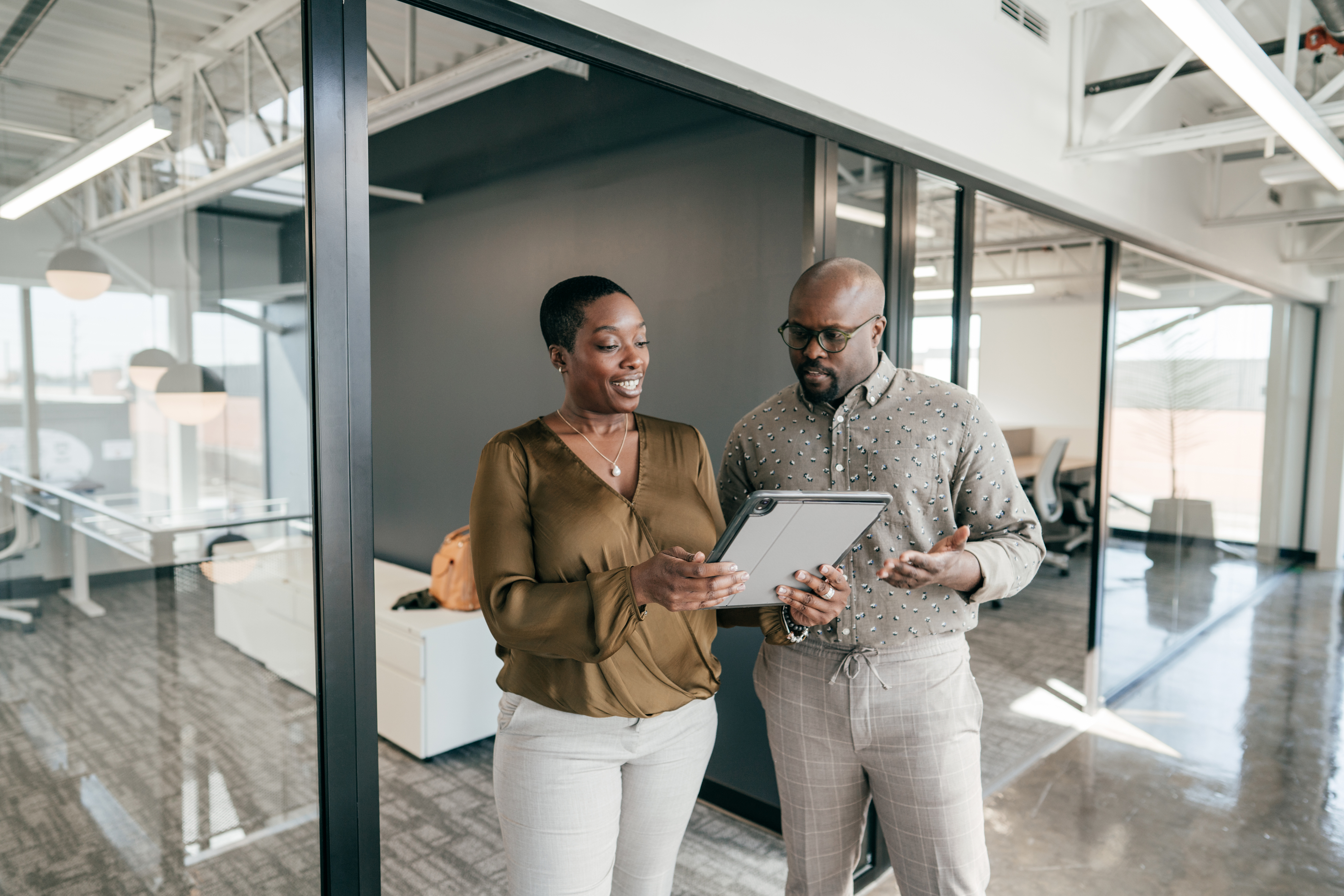 Two people in an office looking at a tablet.