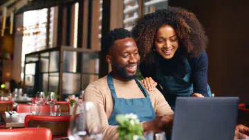 Couple looking at computer together smiling