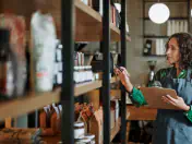 Woman holds clipboard, checks shelves